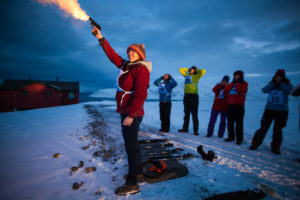 Me shooting a flare gun, during a previous safety training at University Center in Svalbard (credits: Ethan Welty)